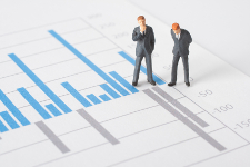 Business report, graph and business figurines illustrating profit decrease analyze.