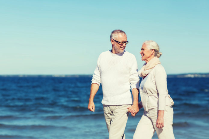 un couple de retraités se balade sur la plage