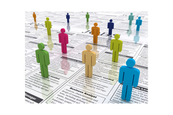 figurines placed on a newspaper in the job vacancies section
