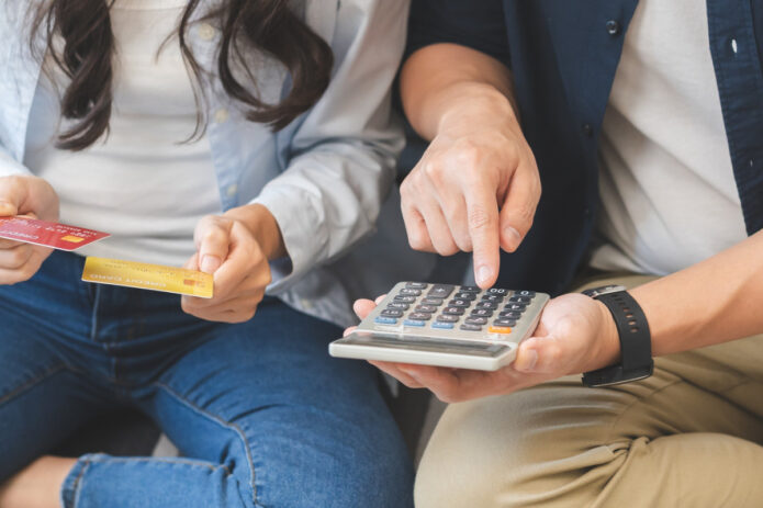 une jeune fille aidée par son père avec une calculette